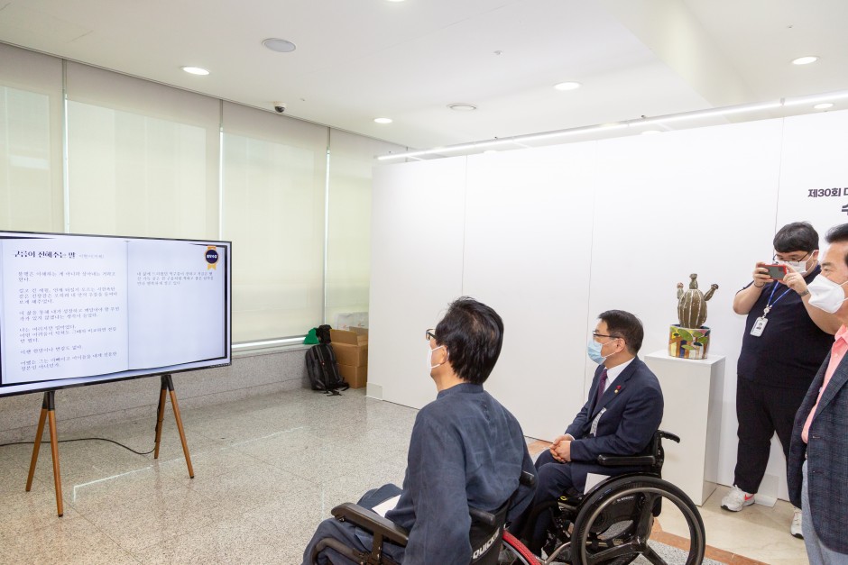 제30회 대한민국장애인문학상·미술대전 수상작의 시를 모니터를 통해 보고 있는 장애인들을 찍은 사진